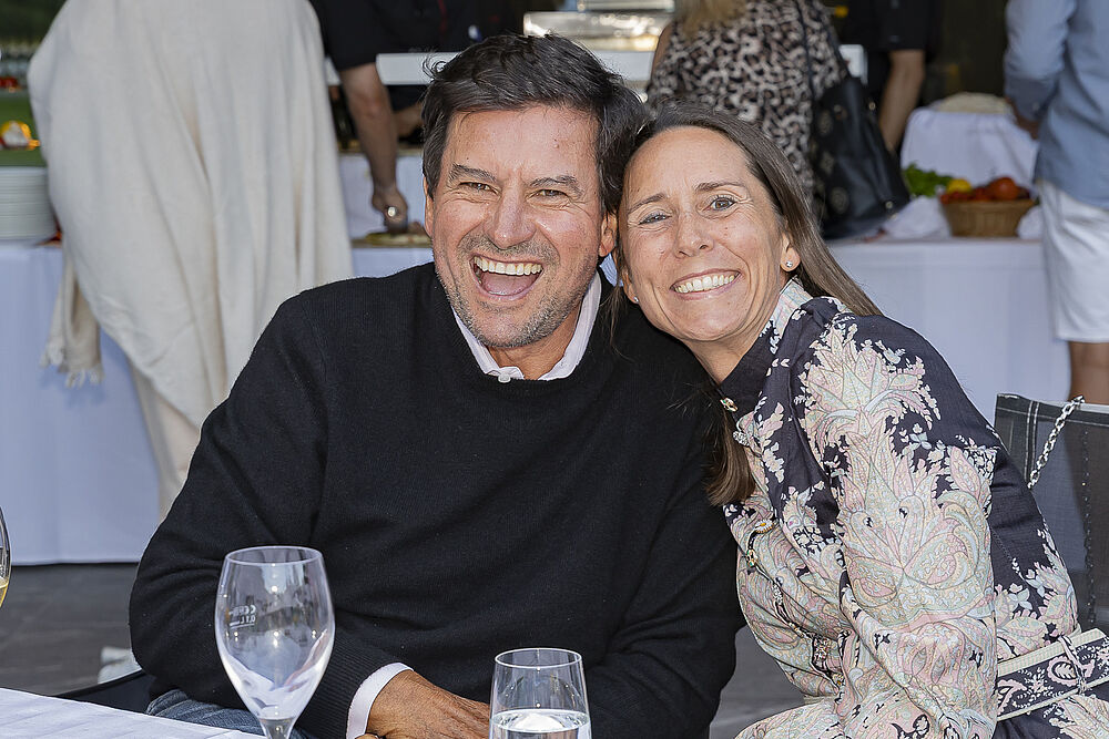 Zwei Personen die aufgeregt in die Kamera lachen. Der Mann, links, trägt ein schwarzen Pullover und die Frau, rechts, trägt ein helles Kleid.